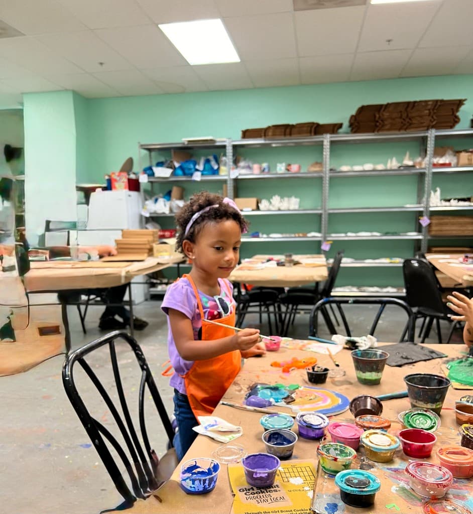 Young child focused on painting at an art table